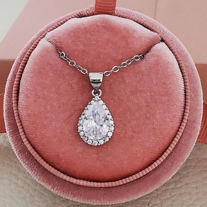 Pear-shaped silver necklace with clear zircon pendant in a pink velvet jewelry box