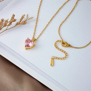 Elegant gold-plated heart pendant necklace with pink zircon on decorative silk and paper