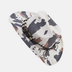 Detailed close-up of cow print felt cowboy hat with ethnic beaded band decoration