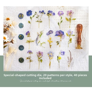 Close-up of dried flower PET stickers and wax seal stamps on textured fabric