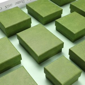 Detailed view of green jewelry boxes featuring intricate floral embossed patterns