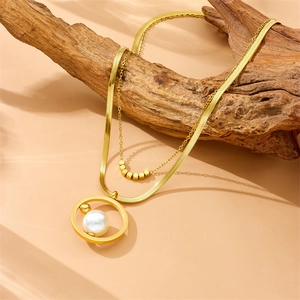 Elegant gold double-layered necklace with pearls draped on a rustic branch