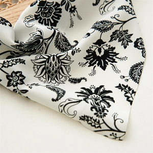 Dettaglio del tessuto con stampa floreale paisley in bianco e nero con trama setosa e cucitura