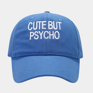 Detail of white CUTE BUT PSYCHO embroidery on blue cotton baseball cap crown