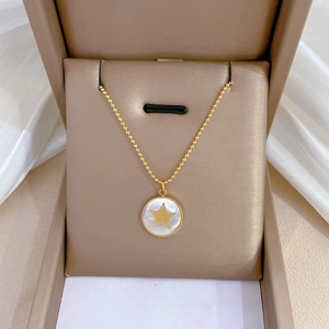 Pendentif étoile dorée avec nacre blanche présenté dans son écrin à bijoux élégant