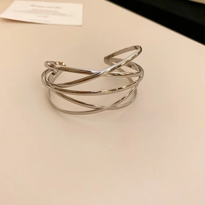 Close-up of polished silver multilayer crossover cuff bracelet with a minimalist design