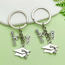 Detail of silver graduation keychains with 2025 and 2026 charms and graduate scroll