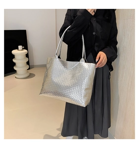 Close-up of oversized silver woven tote bag showing texture and large capacity fit