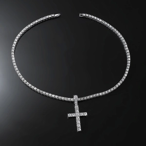 Macro shot of silver tennis chain with iced-out cross pendant and clear cubic zirconia