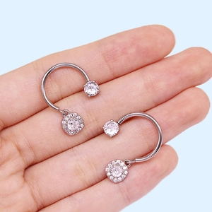 Detail of silver U-shaped earrings with round solitaire and square halo zirconia charms