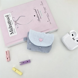 Close-up of light blue star pattern fabric earphone pouch with a pink heart button