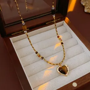 Collier vintage à pendentif cœur marron et perles dorées sur velours