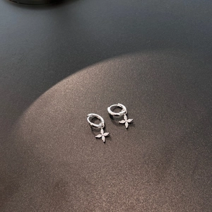 Macro shot of S925 silver hoop earrings with a sparkling four-petal zircon flower charm