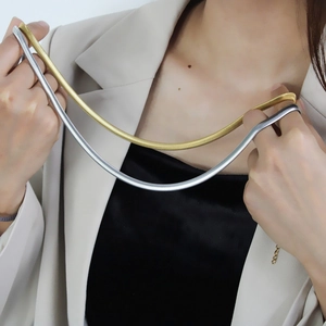 Close-up of 6mm stainless steel gold and silver snake bone necklaces on a model
