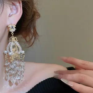 French palace style crystal tassel earrings with pearls on model in gold finish