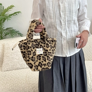Detail of plush leopard print handbag with soft faux shearling texture and zip closure