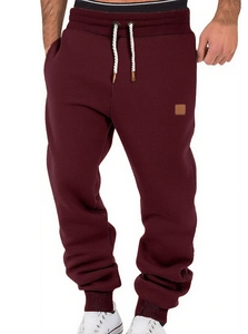 Front view of maroon joggers featuring a black elastic waistband and white drawstrings