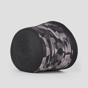 Détail d'un chapeau bob noir tissé à la main avec motif géométrique rose et gris