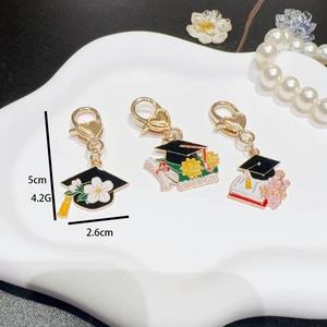 Graduation bachelor hat keychain with daisy sunflower charms and gold heart lobster clasp