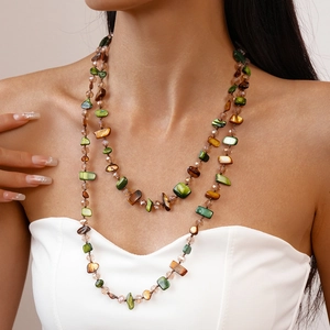 Double-layered necklace with irregular green and brown stone beads on a female model