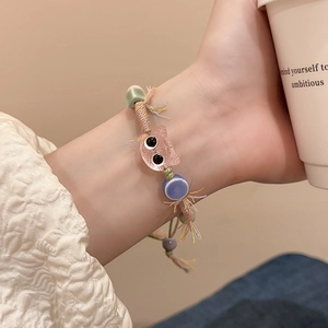 Handmade woven bracelet with cute pink cat charm and colorful beads on model's wrist