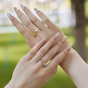 Detail view of gold and silver S925 rings with heart and U-shaped zircon on a model's hand