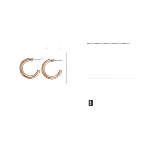Detail showing rose gold C-shaped earrings with ABS material and textured surface