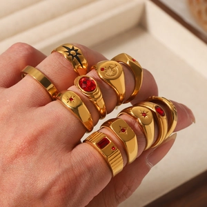 Detail of vintage gold plated rings with star patterns and red gemstones on hand