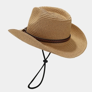 Detailed close-up of straw sun hat featuring a woven leather buckle and adjustable wind cord