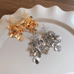 Boucles d'oreilles étoile à franges dorées et argentées avec zircons sur plat céramique