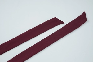 Detailed close-up of dark red knitted halter neck strap fabric texture on lace top