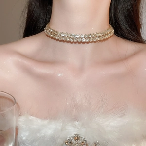 Detailed close-up of a sparkling gold crystal choker necklace on a model's neck