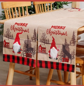 Close-up of beige linen Christmas table runner with 3D gnome and Merry Christmas text