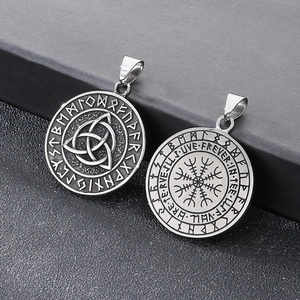 Macro shot of silver titanium steel pendants with Vegvisir and Triquetra Celtic runes