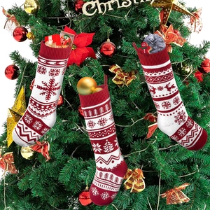 Calze di Natale lavorate a maglia rosse e bianche appese a un albero festivo