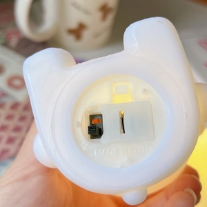 Macro detail of cartoon dog lamp base showing battery compartment and power switch