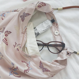 Detail of pink jacquard butterfly bag showing inner zipper pocket and magnetic closure