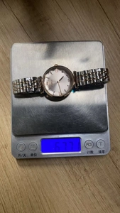 Detailed shot of BIDEN two-tone quartz watch weighing 67.7g on a digital scale