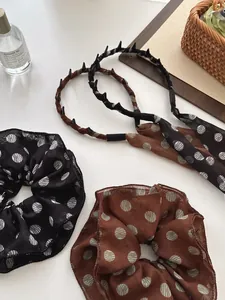 Close-up of French vintage brown polka dot chiffon scrunchies and ribbon headbands