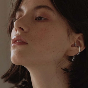 Minimalist silver irregular ear cuff shown on a model's ear for a cool unisex style