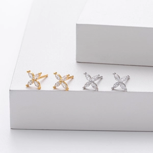 Macro view of gold and silver clover stud earrings set with sparkling marquise zircons