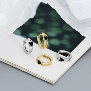 Macro shot of gold and silver heart-shaped earrings on an open book page