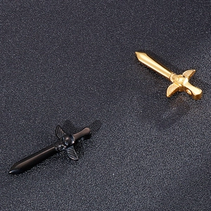 Détail de pendentifs épée gothique avec crâne et ailes en finitions dorée et noire