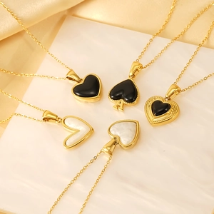 Five assorted gold heart and spade necklaces displayed on white and gold satin backdrop