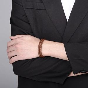Close-up of a double-wrap brown leather braided bracelet with an anchor clasp for men