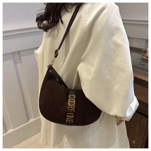 Brown suede crescent underarm bag with gold metal hardware and leather strap on model