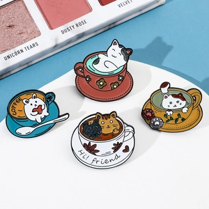 Detail of four creative cartoon cat coffee cup enamel pins set on a white round display stand