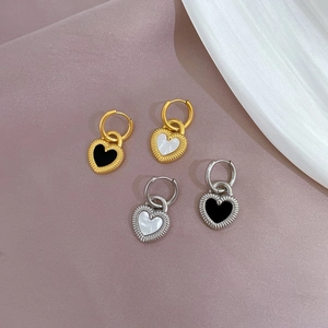 Detail of heart shell earrings in gold and silver finish with enamel inlay work