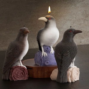 Three crow candles on tree stumps with realistic feather textures and lit candle flame
