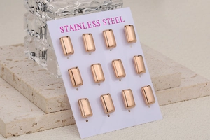 Set of 12 rose gold rectangular stainless steel stud earrings on a white display card